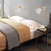 Bedroom with a bed, nightstands, and wall sconces.